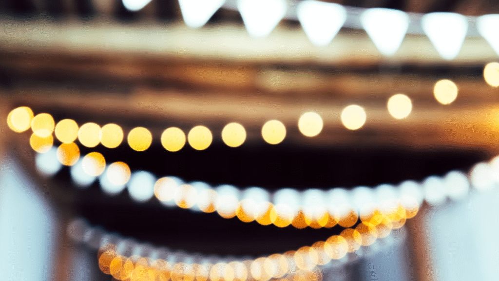 glowing event light strands hanging overhead with a blurred background, symbolizing emerging fundraising event trends for 2026
