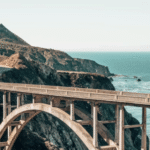 A bridge winding through mountains over the ocean, representing building connections and strengthening relationships between staff and board members.
