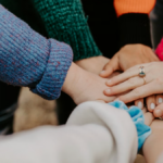Hands stacked together symbolizing shared responsibility and clear board–staff roles