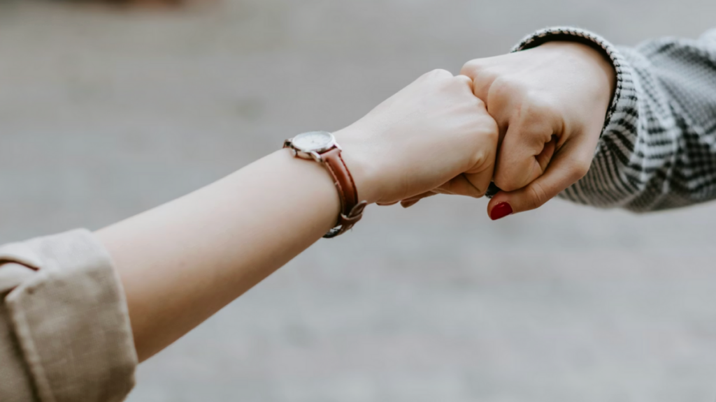 Two hands fist bumping to represent accountability and trust among nonprofit board members