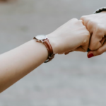 Two hands fist bumping to represent accountability and trust among nonprofit board members