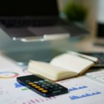 Laptop, calculator, and printed financial data used for nonprofit budgeting and planning.