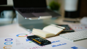 Laptop, calculator, and printed financial data used for nonprofit budgeting and planning.
