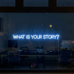 Neon sign reading “What’s your story?” symbolizing nonprofit board members sharing mission stories to engage donors and community partners.