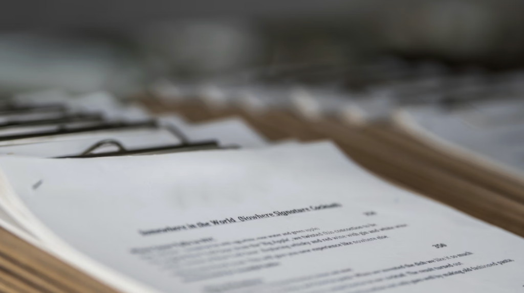 Stack of documents on a clipboard representing structured agendas, motions, and procedures used to run nonprofit board meetings effectively.
