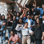 Group of nonprofit volunteers cheering together outside a building, representing strong volunteer engagement and retention in a community program.