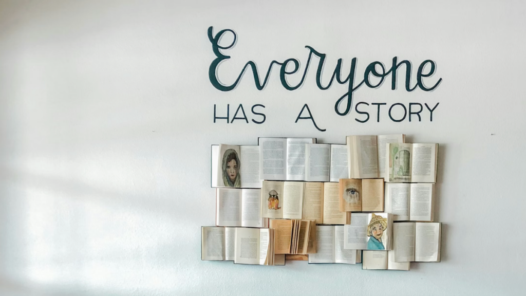 Opened books arranged as art with the phrase "everyone has a story" above them
