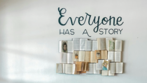 Opened books arranged as art with the phrase "everyone has a story" above them