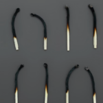 Two rows of six burned matches illustrating overwork and burnout