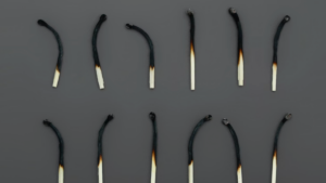 Two rows of six burned matches illustrating overwork and burnout