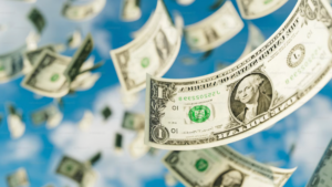 Money falling from a blue sky with white clouds, symbolizing recurring revenue for nonprofits beyond grants