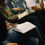 Workshop participants seated with open notebooks, ready for a staff training session