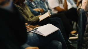 Workshop participants seated with open notebooks, ready for a staff training session