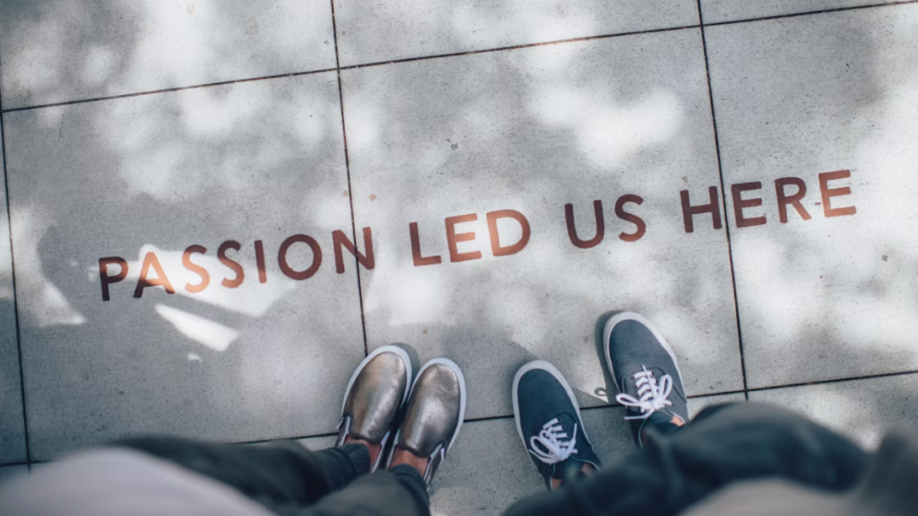 Team members standing on a sidewalk with the words "passion led us here" painted at their feet