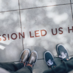 Team members standing on a sidewalk with the words "passion led us here" painted at their feet