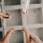 Upward view of team members' hands clasped together in celebration