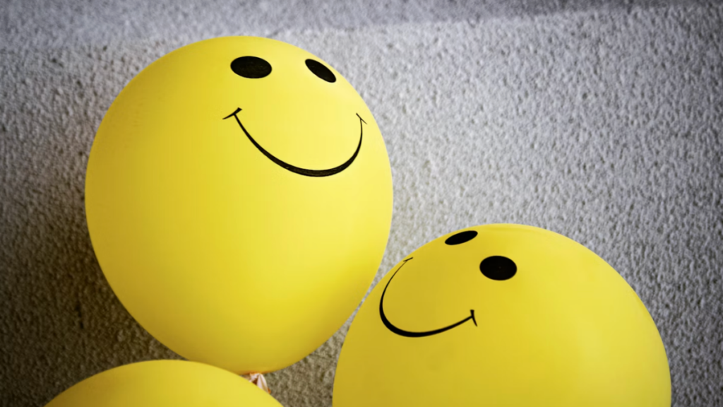 Yellow balloons with smiling faces drawn on them