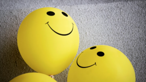 Yellow balloons with smiling faces drawn on them